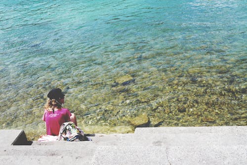 昼間に海の前に座っている女性