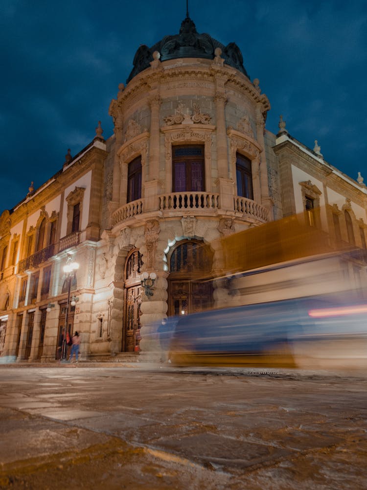 Blurred Car Near Macedonio Alcala Theatre In Oaxaca De Juarez In Mexico In Evening