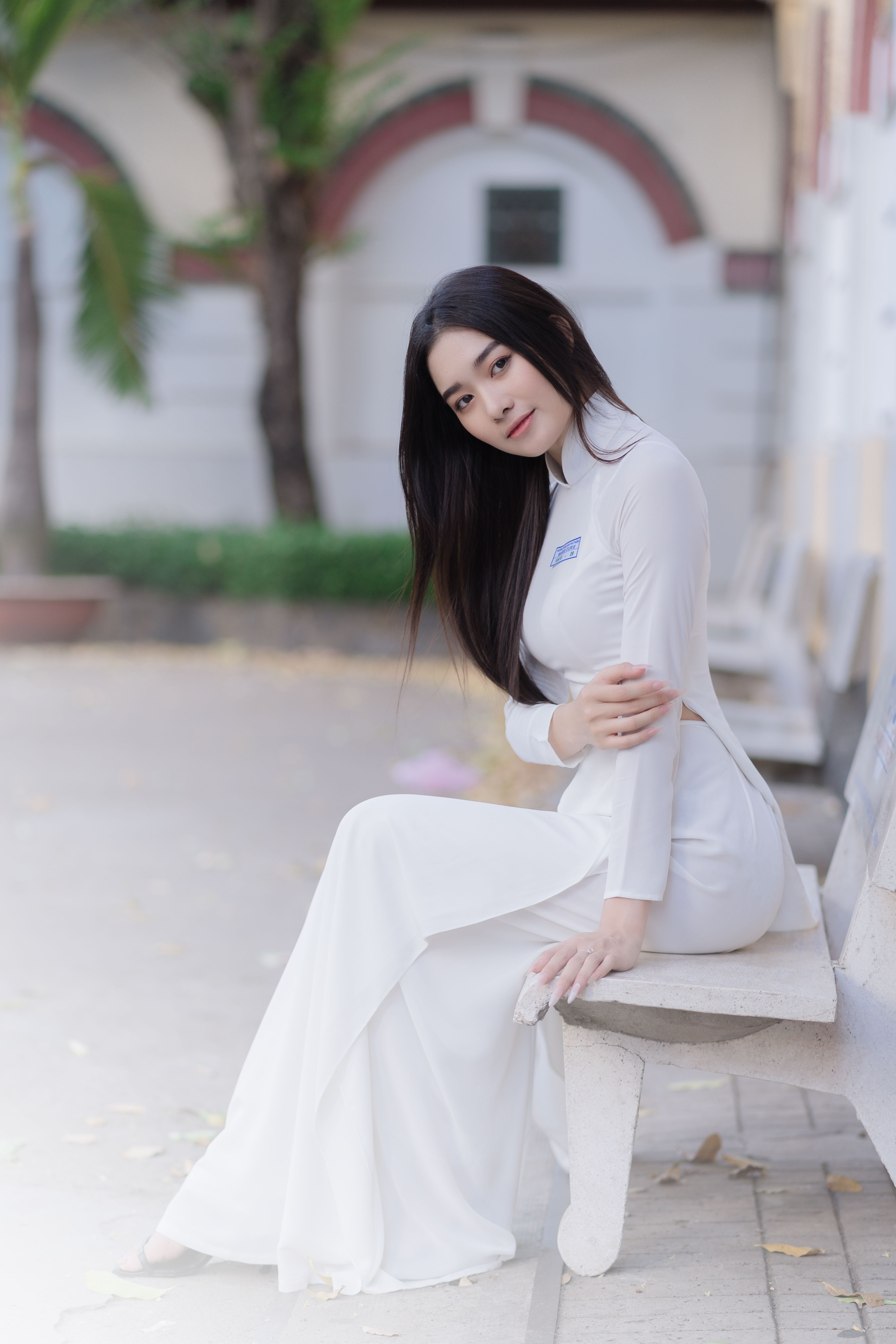 Young Woman in an Elegant White Dress Sitting on a Bench · Free Stock Photo