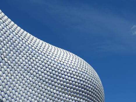 Futuristic modern facade of Selfridges in Birmingham under a clear blue sky.