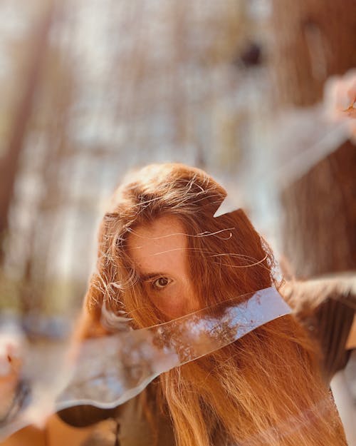 Portrait of a Long-Haired Redhead Holding Pieces of Frosted Glass