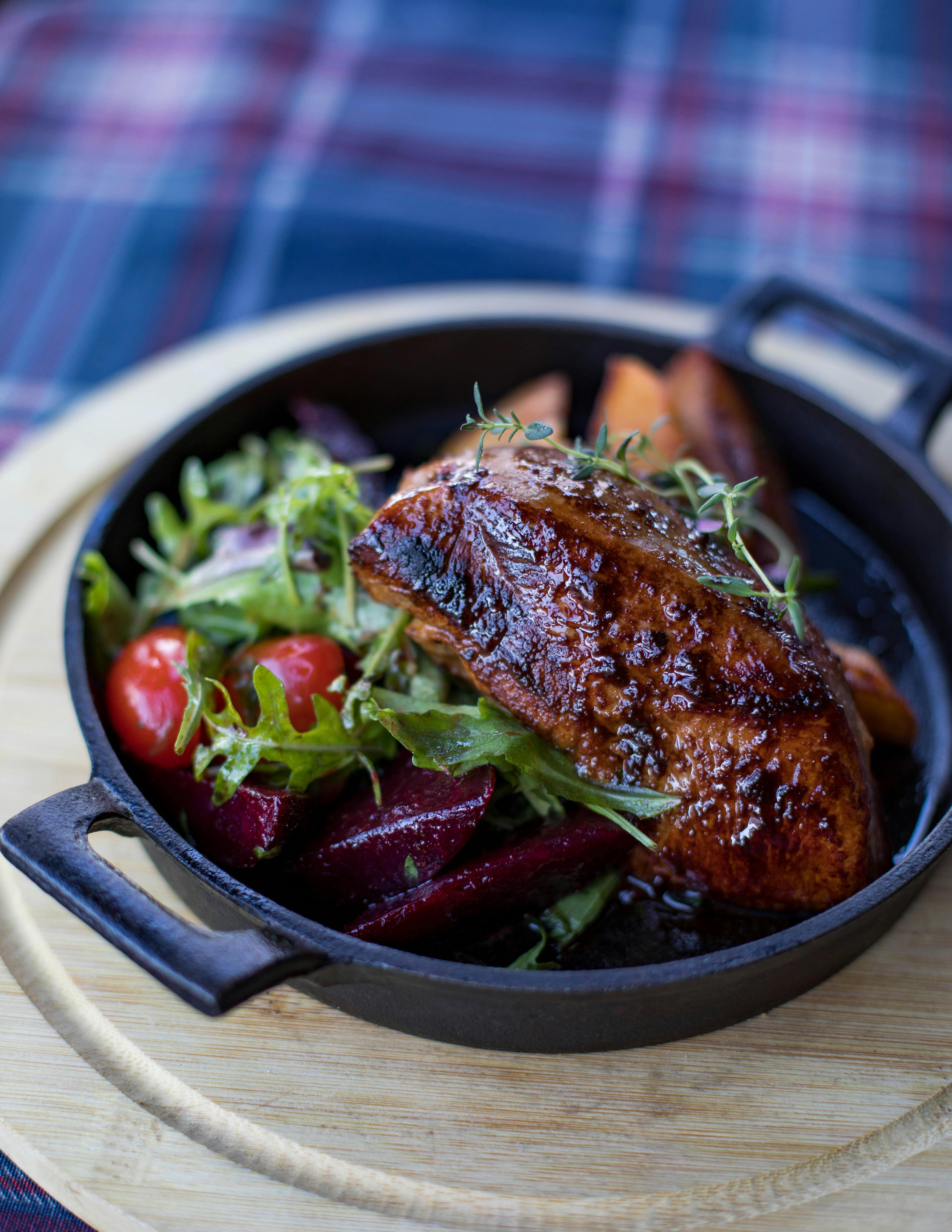 铸铁煎锅里的烤肉，搭配沙拉和蔬菜，美味又丰盛