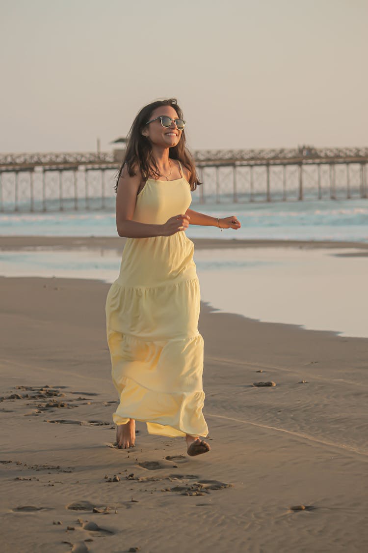 Smiling Woman Running On Beach