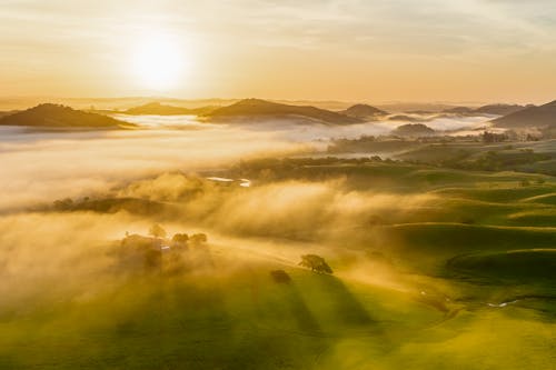 A sunrise over a valley with fog and mist