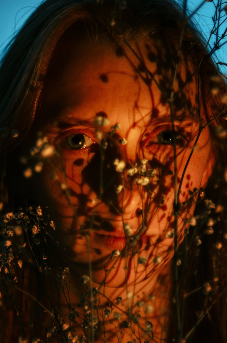 Light On Woman Face Behind Branches