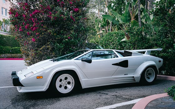 A classic white sports car parked on a street in lush Beverly Hills, CA.