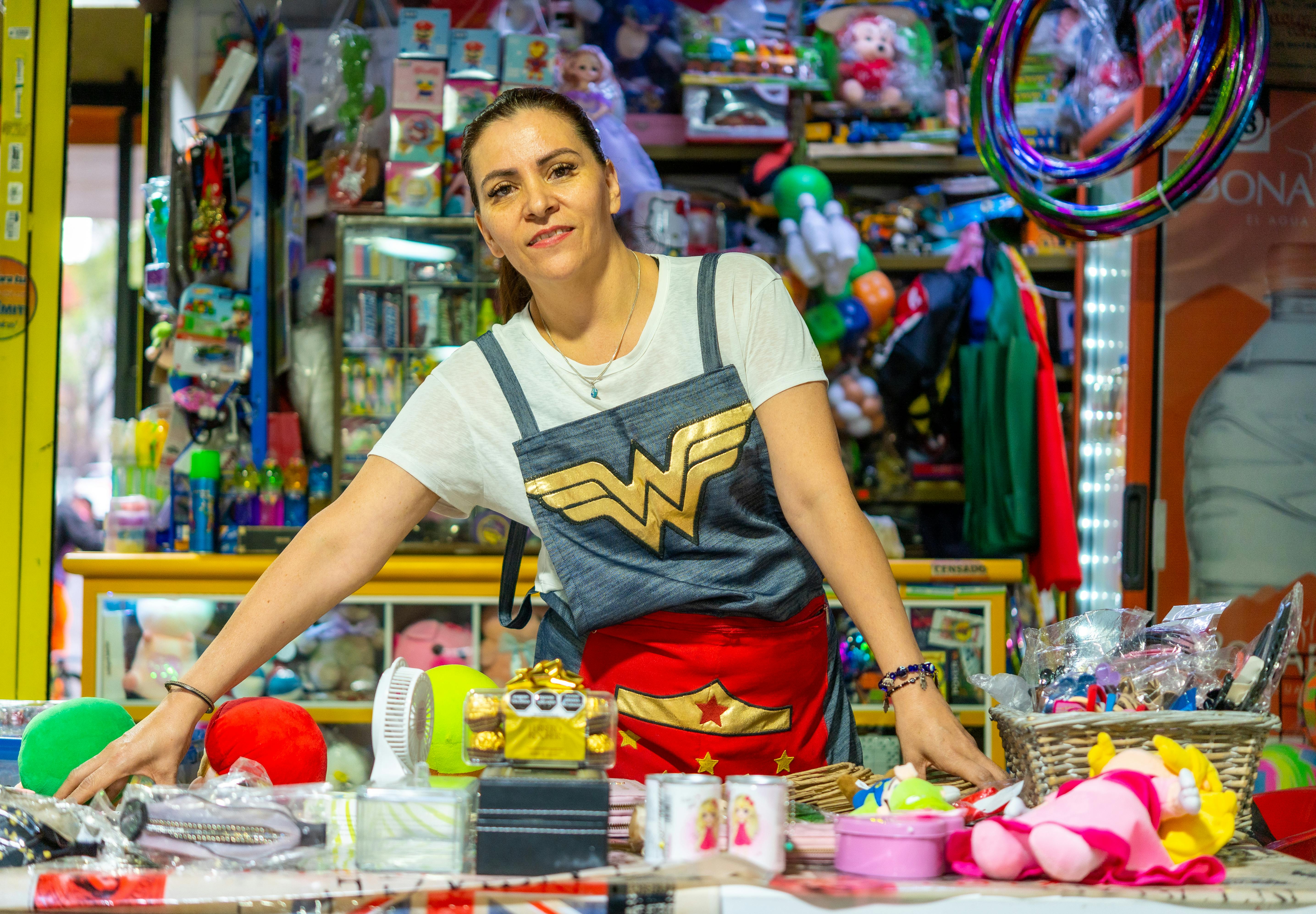 a woman in a wonder woman costume stands behind a counter