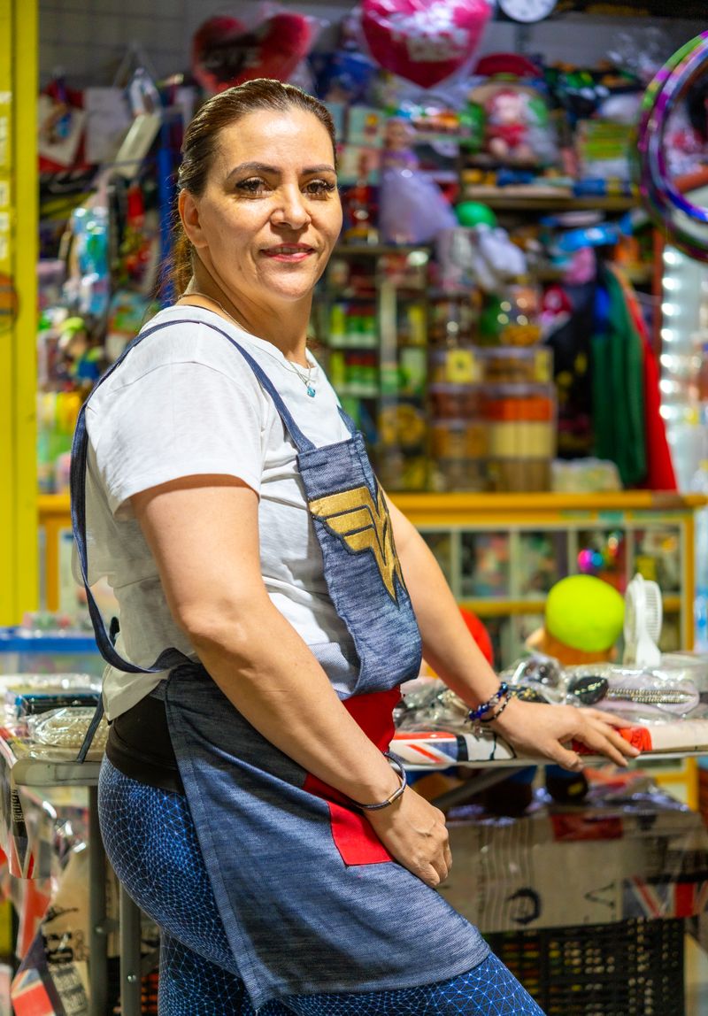 Dueña de una bodega peruana sonriendo detrás de su mostrador