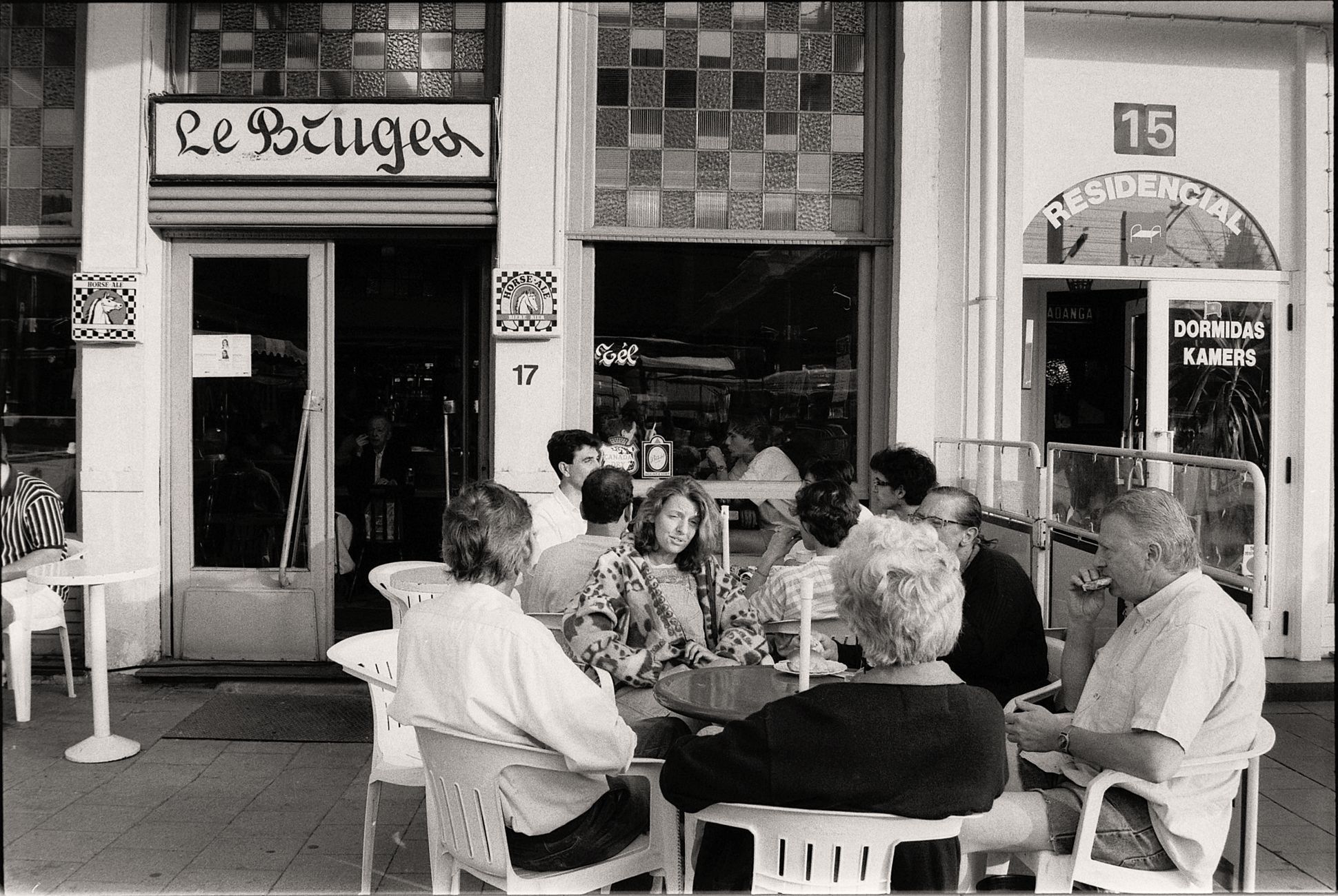 Group of people enjoying a conversation at an outdoor cafe.