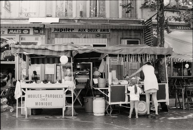 Woman With Her Daughter Shopping At A Fish Stand 