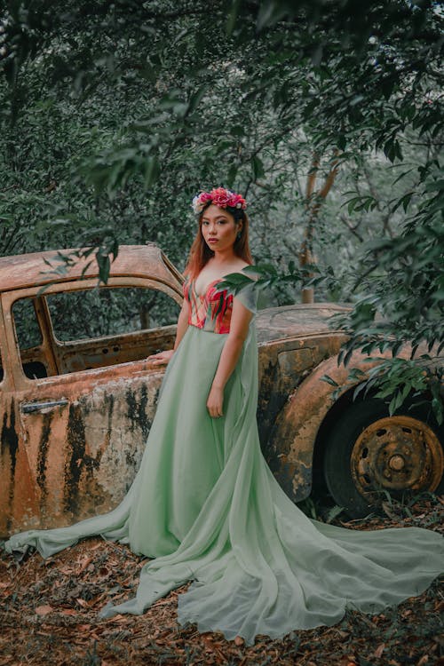 Girl Wearing Teal and Red Dress Standing Near Abandon Vehicle