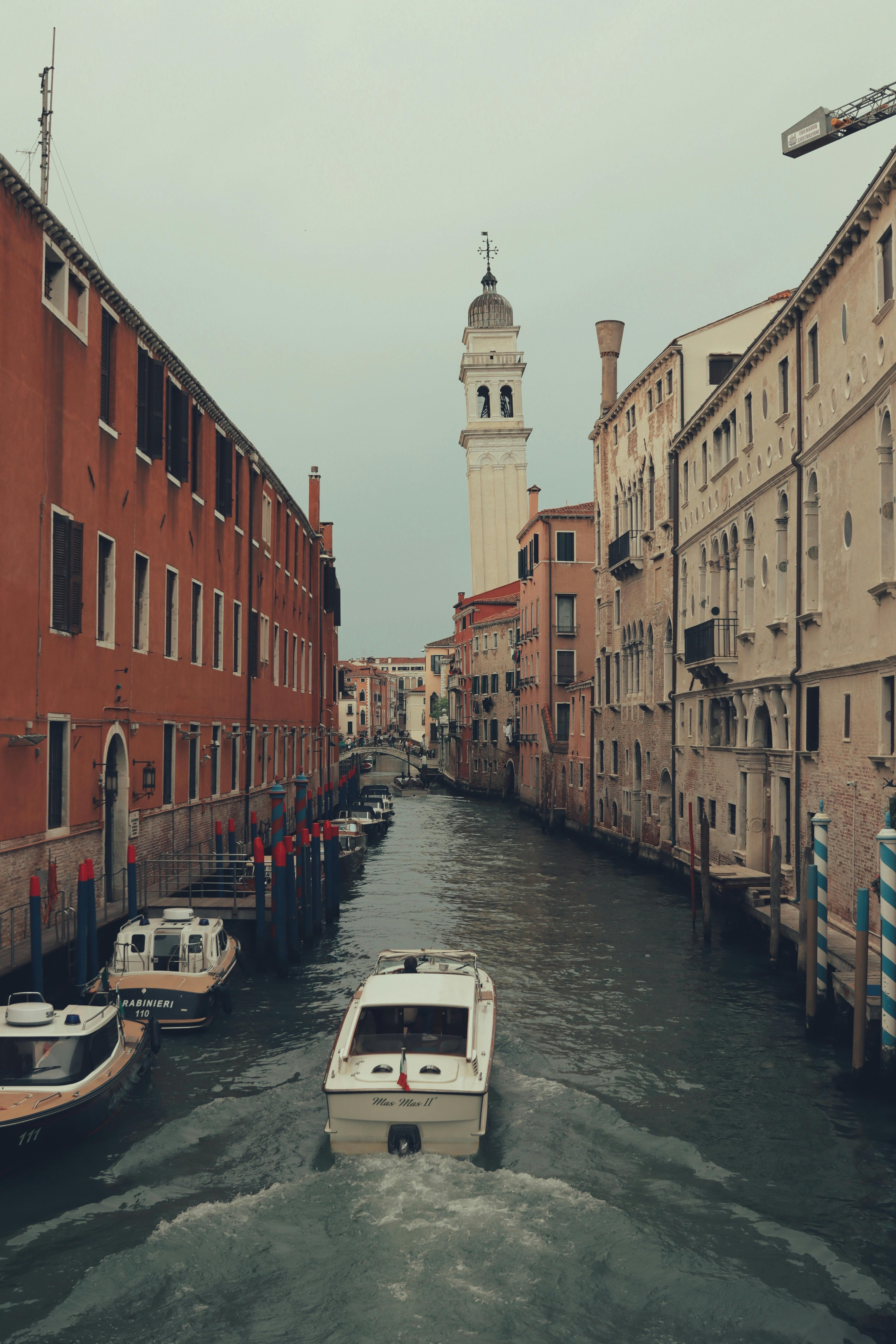 A picturesque canal in Venice, Italy, featuring a historic tower and charming architecture.