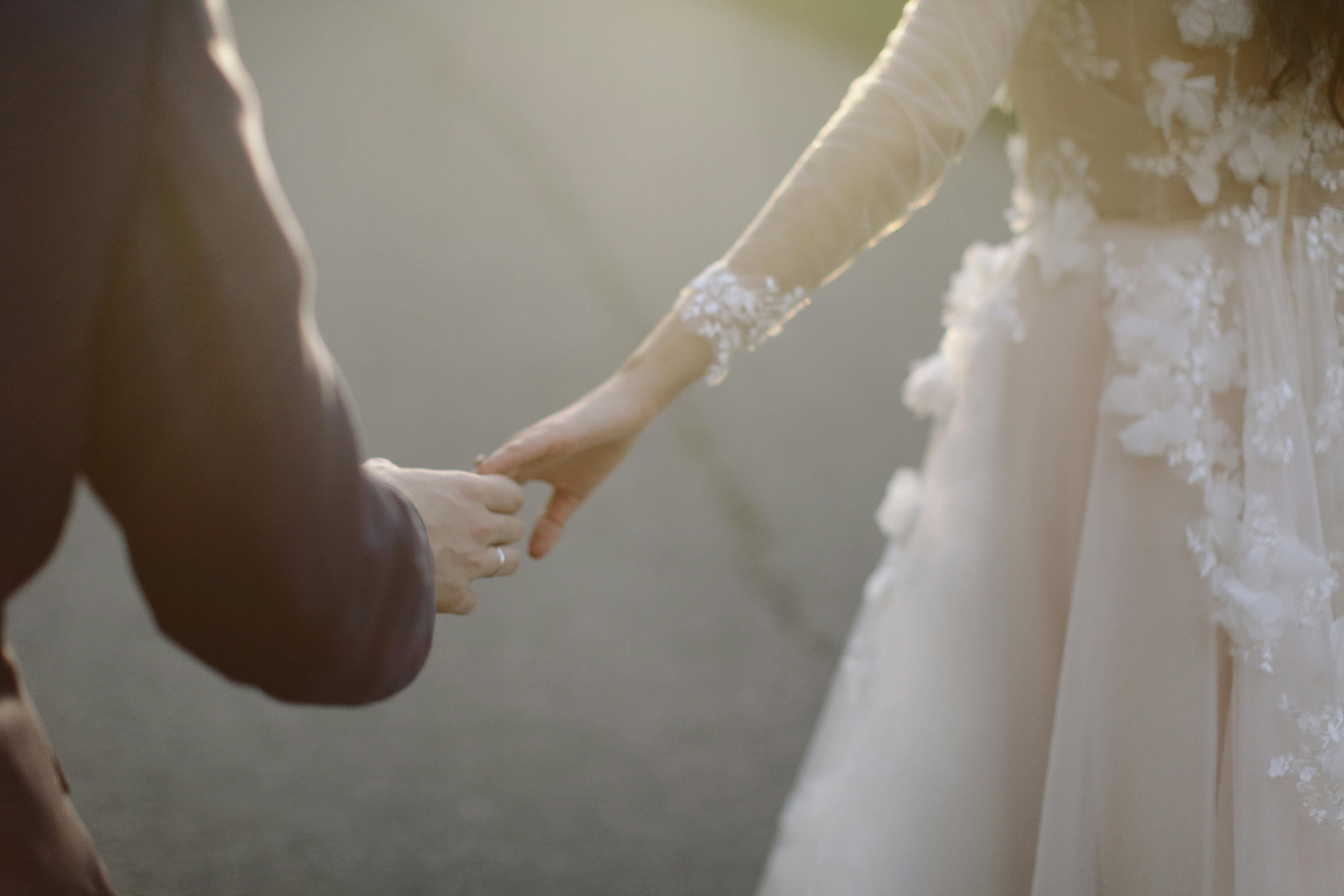 Newlyweds holding hands. | Photo: Pexels