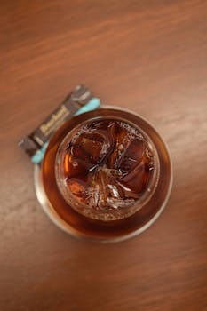 High angle view of a refreshing iced coffee with chocolate on a wooden table.
