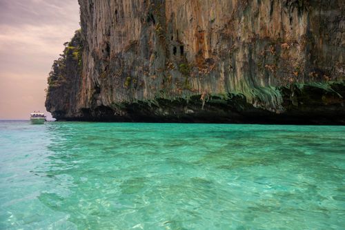Free Turquoise waters and towering cliffs create a picturesque seascape, perfect for a tranquil boat ride. Stock Photo