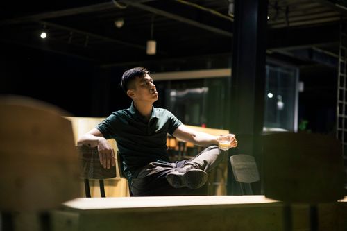 Free Young man posing indoors, enjoying a drink at a stylish urban café. Stock Photo