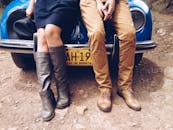 一男一女坐在一辆蓝色复古大众甲壳虫上展示鞋子