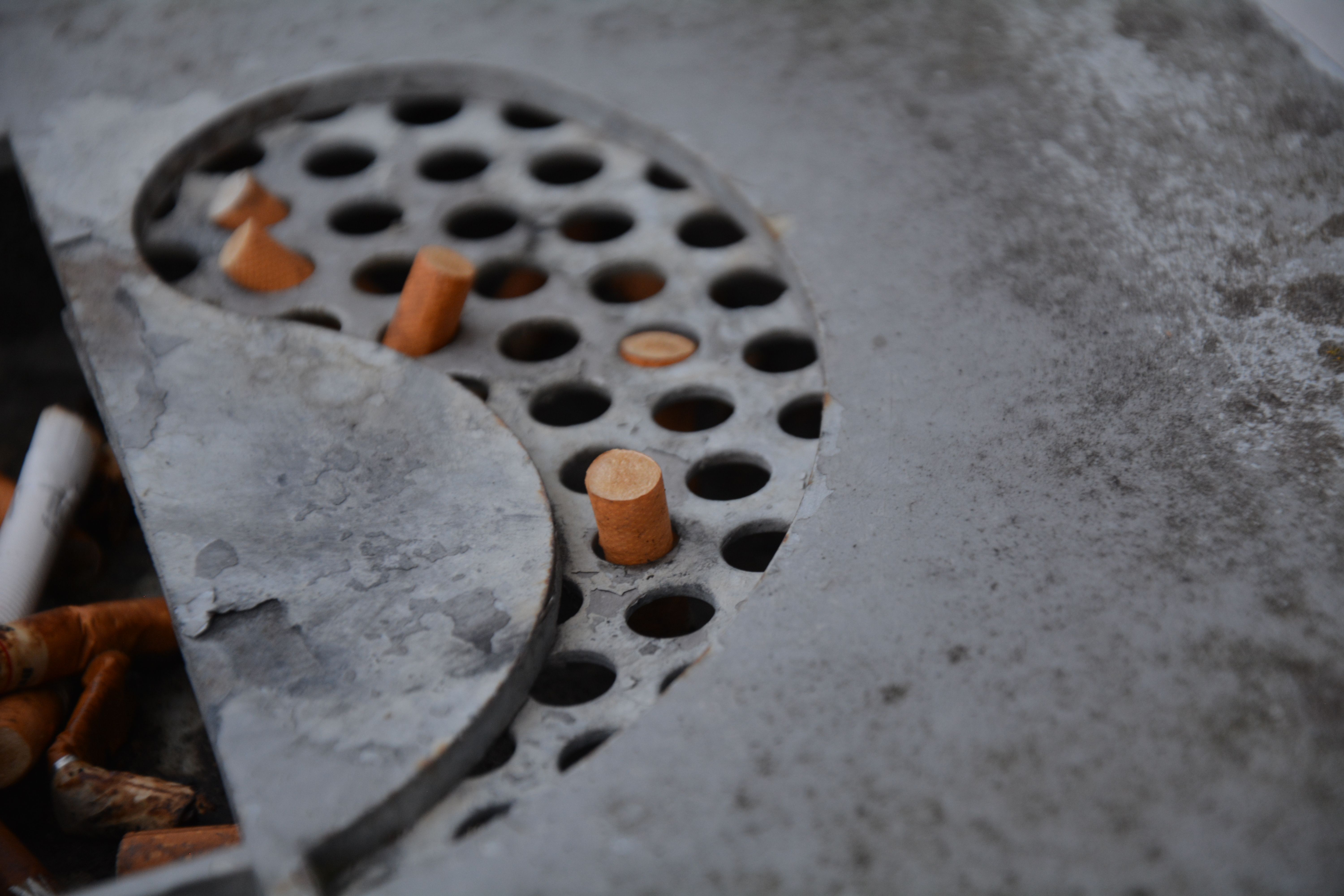 Close up of Cigarettes in Ashtray Holes · Free Stock Photo