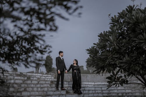 Romantic Couple in Evening Dress Standing on Steps in a Park