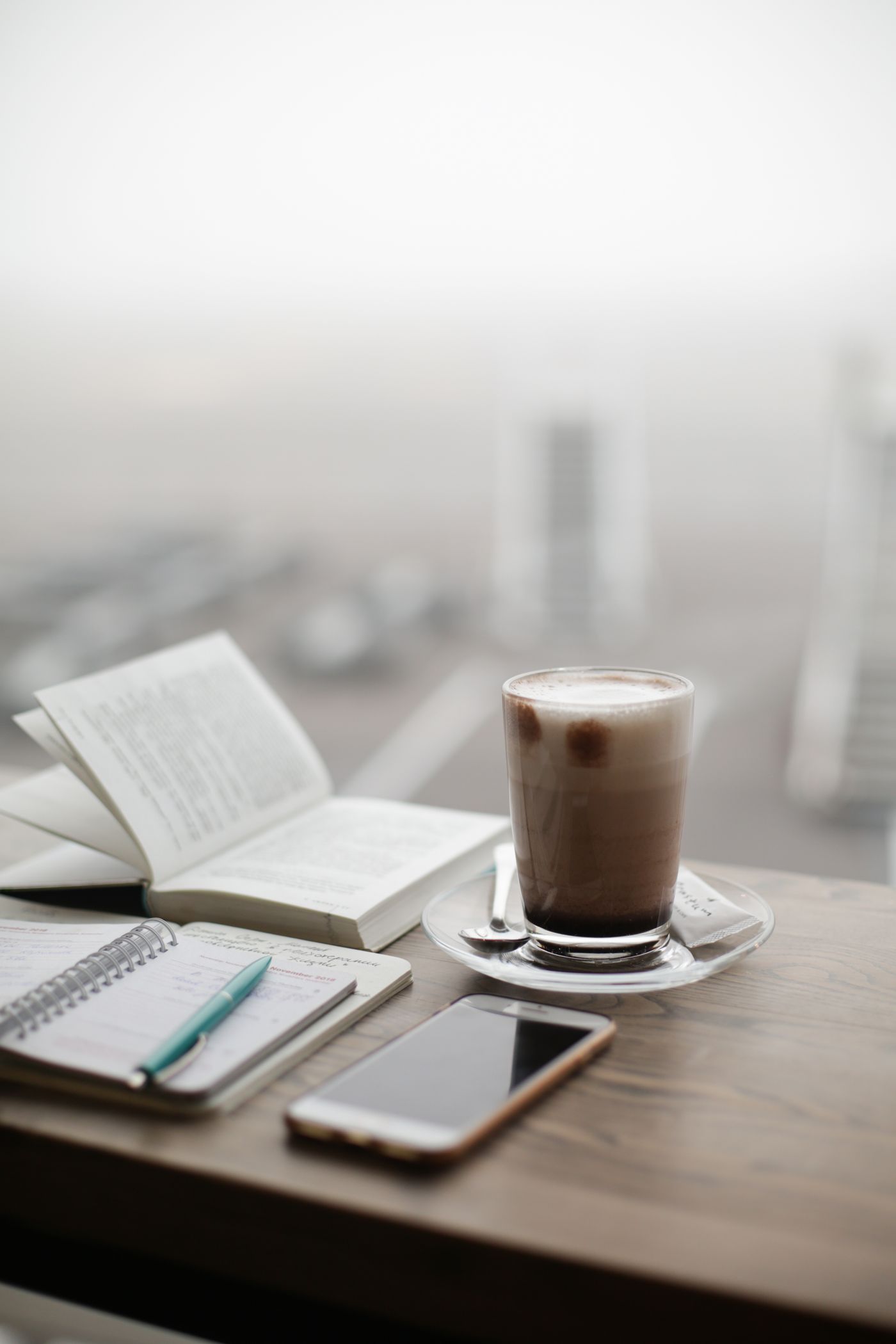 A latte beside an open book on a quiet cafe table