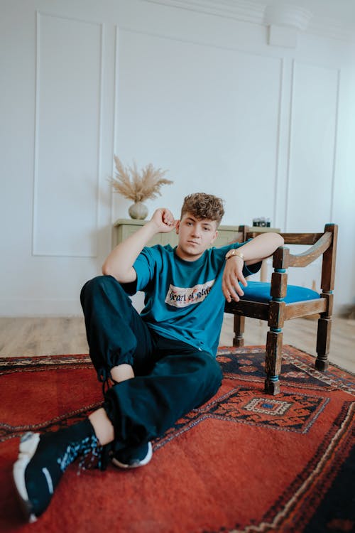 Young Man Sitting on Carpet