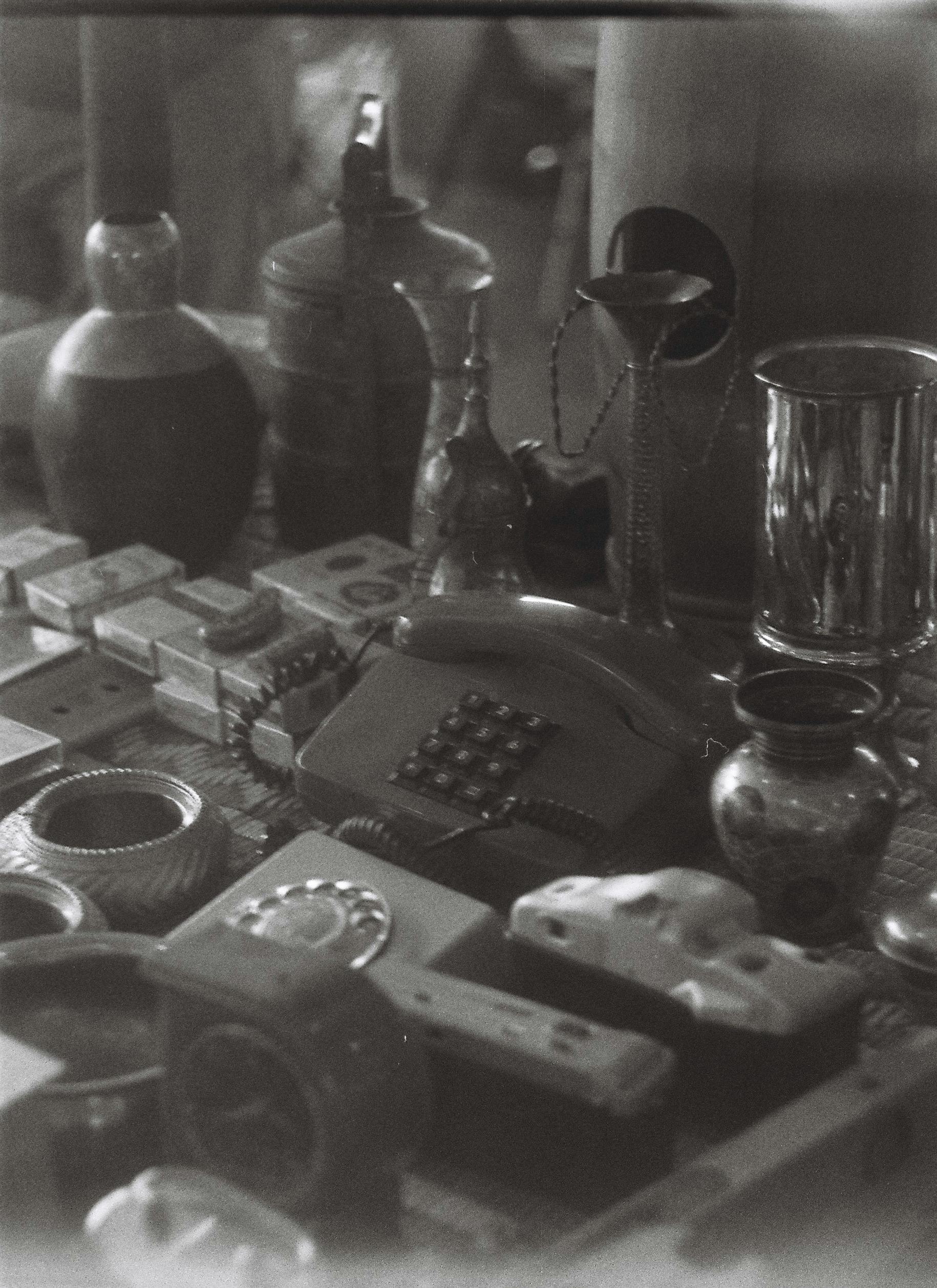 Black and white vintage items including a rotary phone and ornate vases on display.