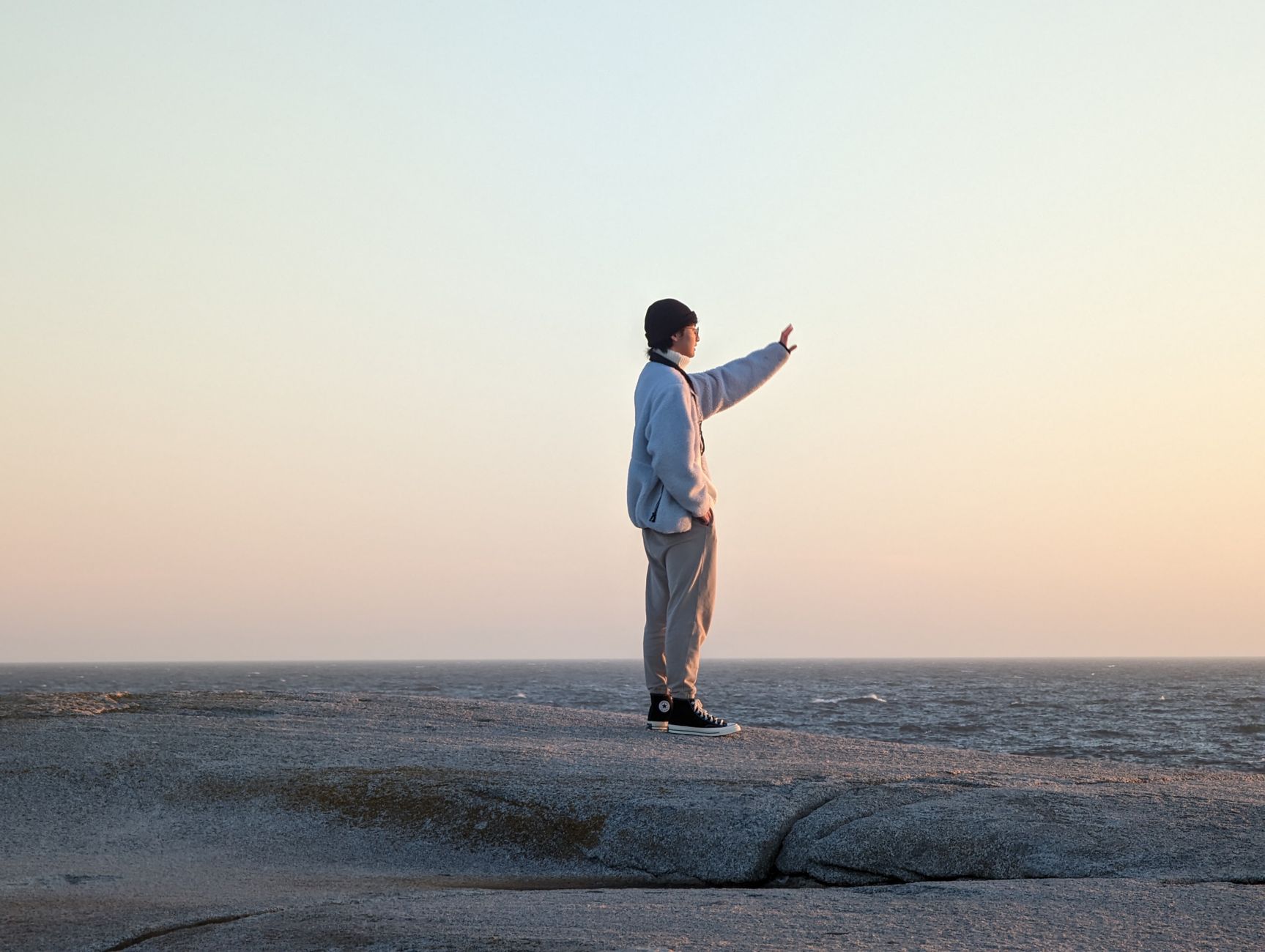 A serene moment at Peggys Cove with a person gazing into the sunset view.