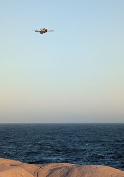 A serene shot of a drone flying above the rocky shores of Peggys Cove, capturing the vast sea.