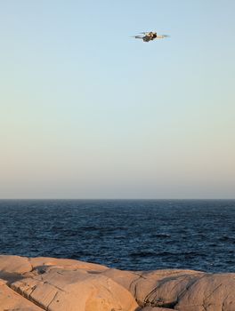 Captured drone hovering above rocky coast of Peggys Cove, Nova Scotia, scenic ocean view.
