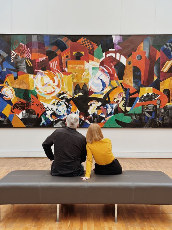 People looking at a painting in an art gallery