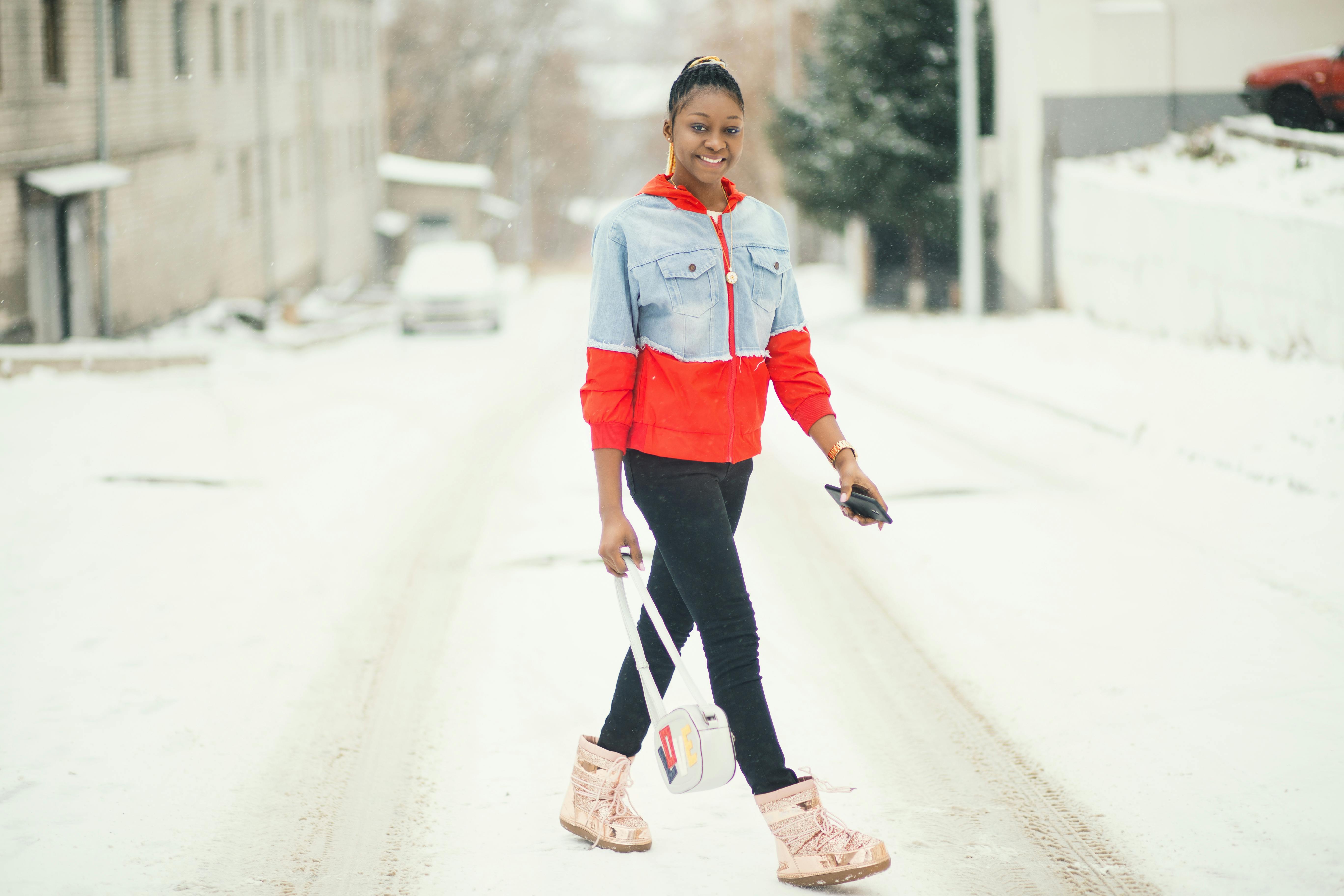 一位时尚女子自信地走在积雪的街道上，身着冬装