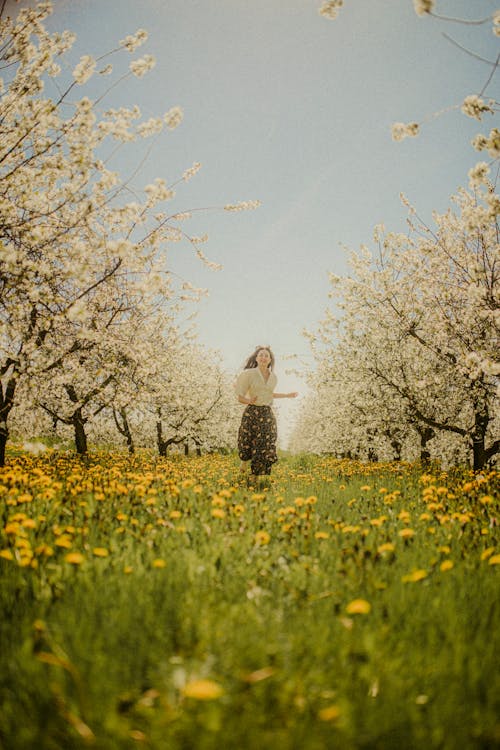 Woman Running in Blossoming Orchard