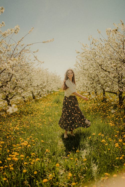 Woman Standing on Blossoming Orchard