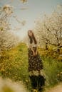 Woman Standing in Blossoming Orchard