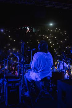 A dynamic live concert scene with a musician playing drums, captivating a vibrant audience.