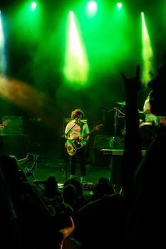 A dynamic live concert scene with a guitarist on stage under vibrant lighting. Perfect for music-related themes.