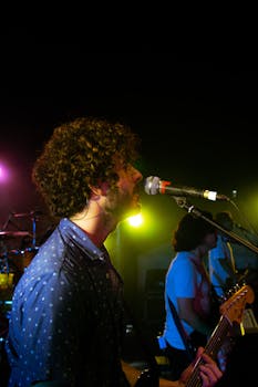 Musicians performing on stage with dynamic lighting, creating a lively concert atmosphere.