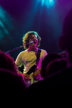 A vibrant live music performance featuring a guitarist passionately playing on stage.