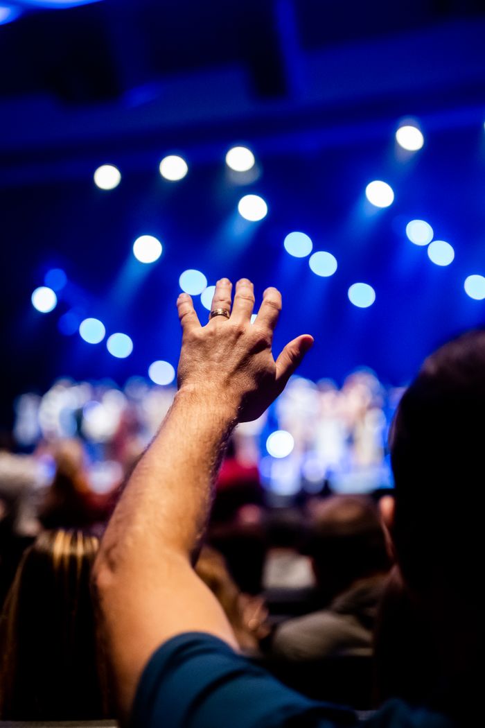 Raised hands in a concert crowd, by Caleb Oquendo on Pexels