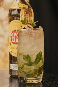 Close-up of a refreshing mojito cocktail with mint and lime in front of a Havana Club bottle.