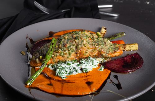 Free A beautifully plated salmon dish with vibrant vegetables and sauce, perfect for a gourmet dining experience. Stock Photo