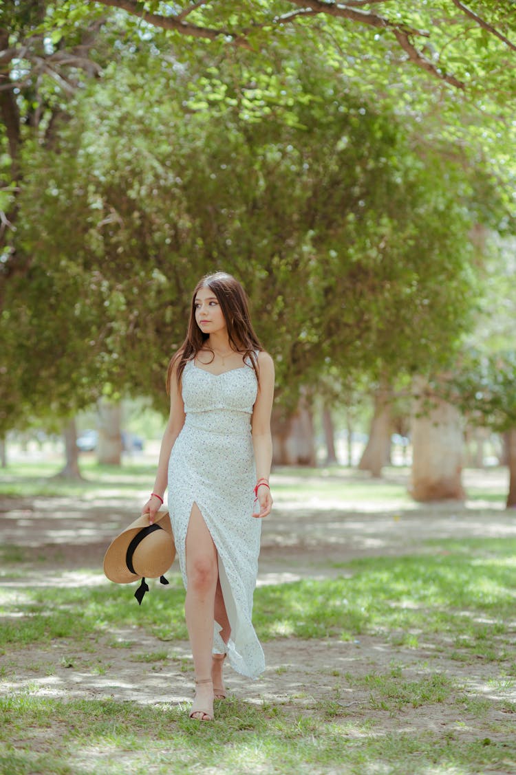 Woman In Sundress Walking Through Park