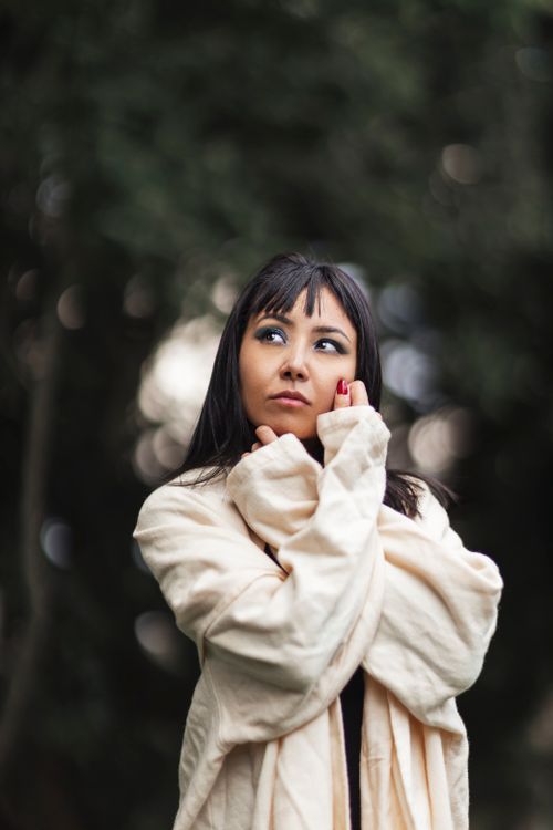 Free A thoughtful woman in a cozy coat stands outdoors with a contemplative expression. Stock Photo