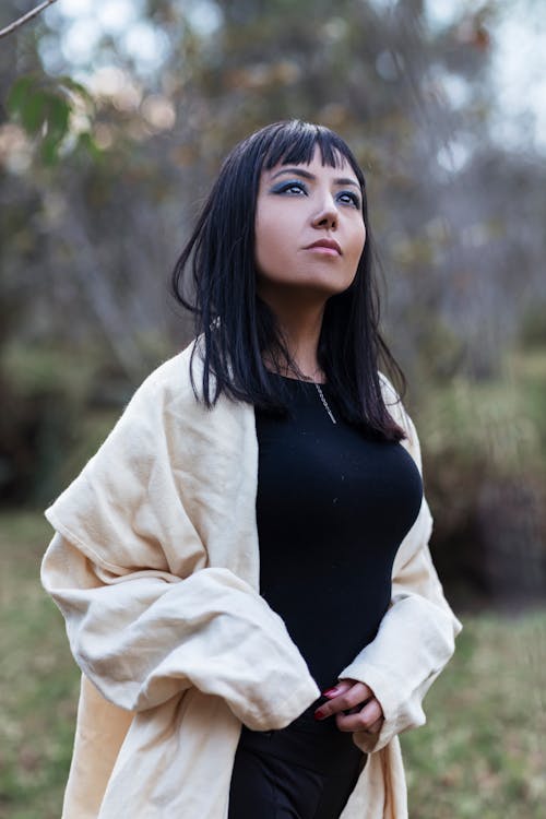 Beautiful Brunette Woman in Beige Cardigan Standing in Park