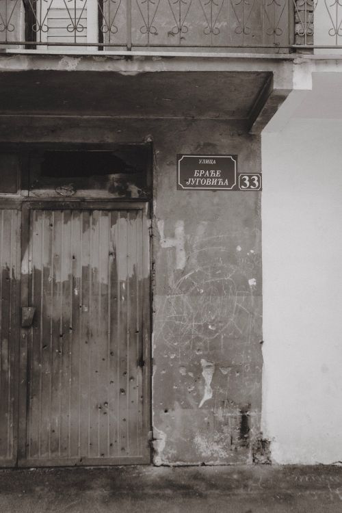 Free An aged city street entrance with a weathered doorway and street sign. Stock Photo