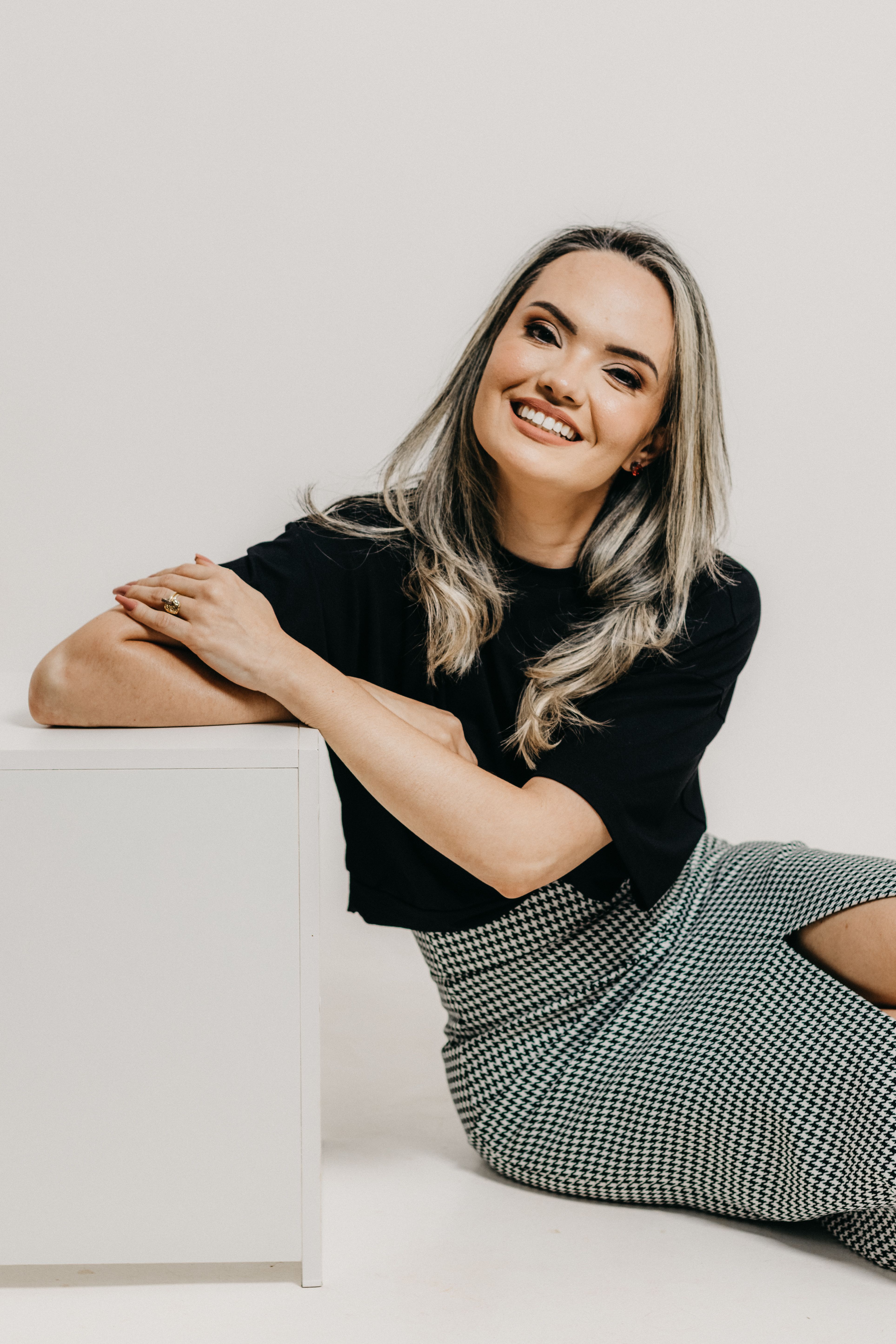 Happy woman posing indoors with a confident smile, exuding style and elegance.