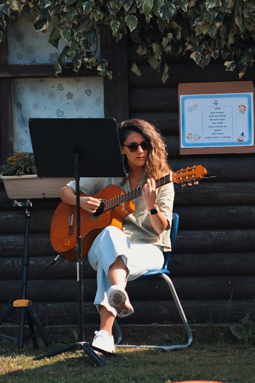 Woman Sitting and Playing Guitar