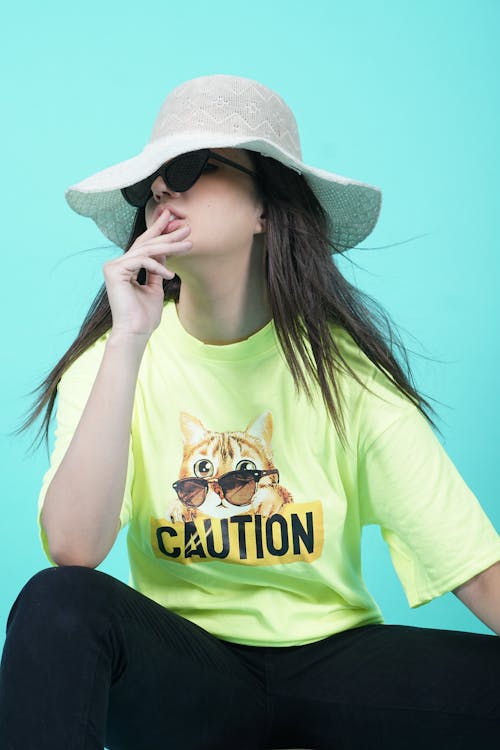 Woman Sitting and Posing in Hat and T-shirt