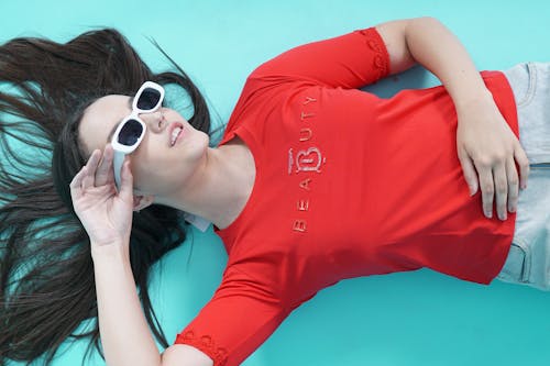 Woman in Sunglasses Lying on Blue Floor