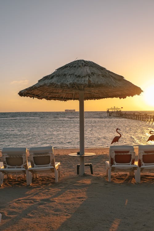 Thatched Sunshade on Beach at Sunset